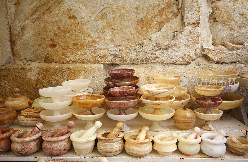 在Selcuk Bazaar上，各种大小的大理石制成的臼、杵和底座碗并排排列在货架上，有浅棕色、白色、灰色、奶油色和肉桂色